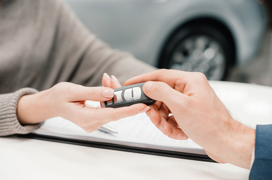 Two hands holding vehicle keys completing a car deal
