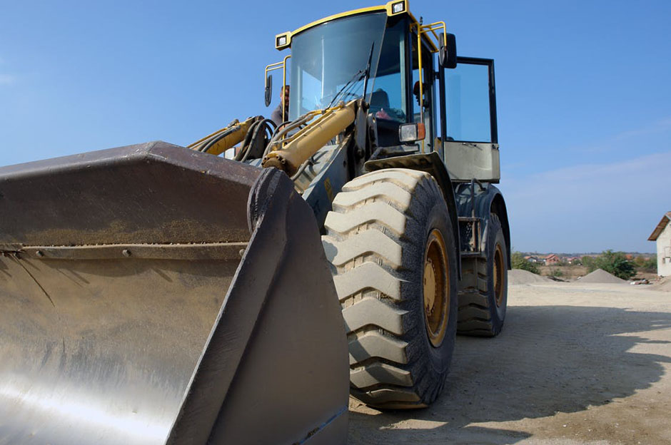 A bulldozer close up on construction site with a clear blue sky background