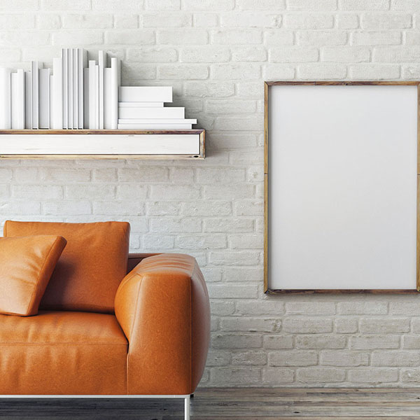 Close up of a brown leather sofa against a white brick wall - Furniture banner