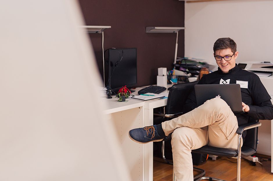 Men smiling while using a laptop computer