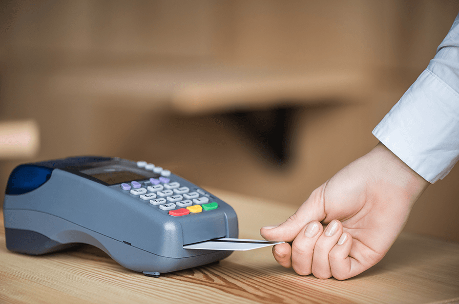 Hand inserting a card into a POS terminal for payment